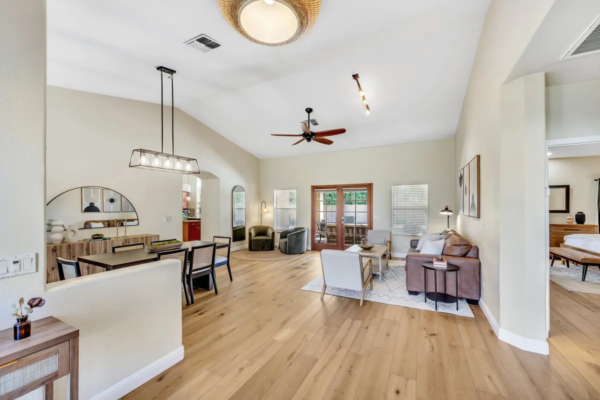 Depicts a bright dining area with a wooden table and comfortable seating, flooded with natural light from large windows. The space feels welcoming and is well-suited for both family dinners and special celebrations.