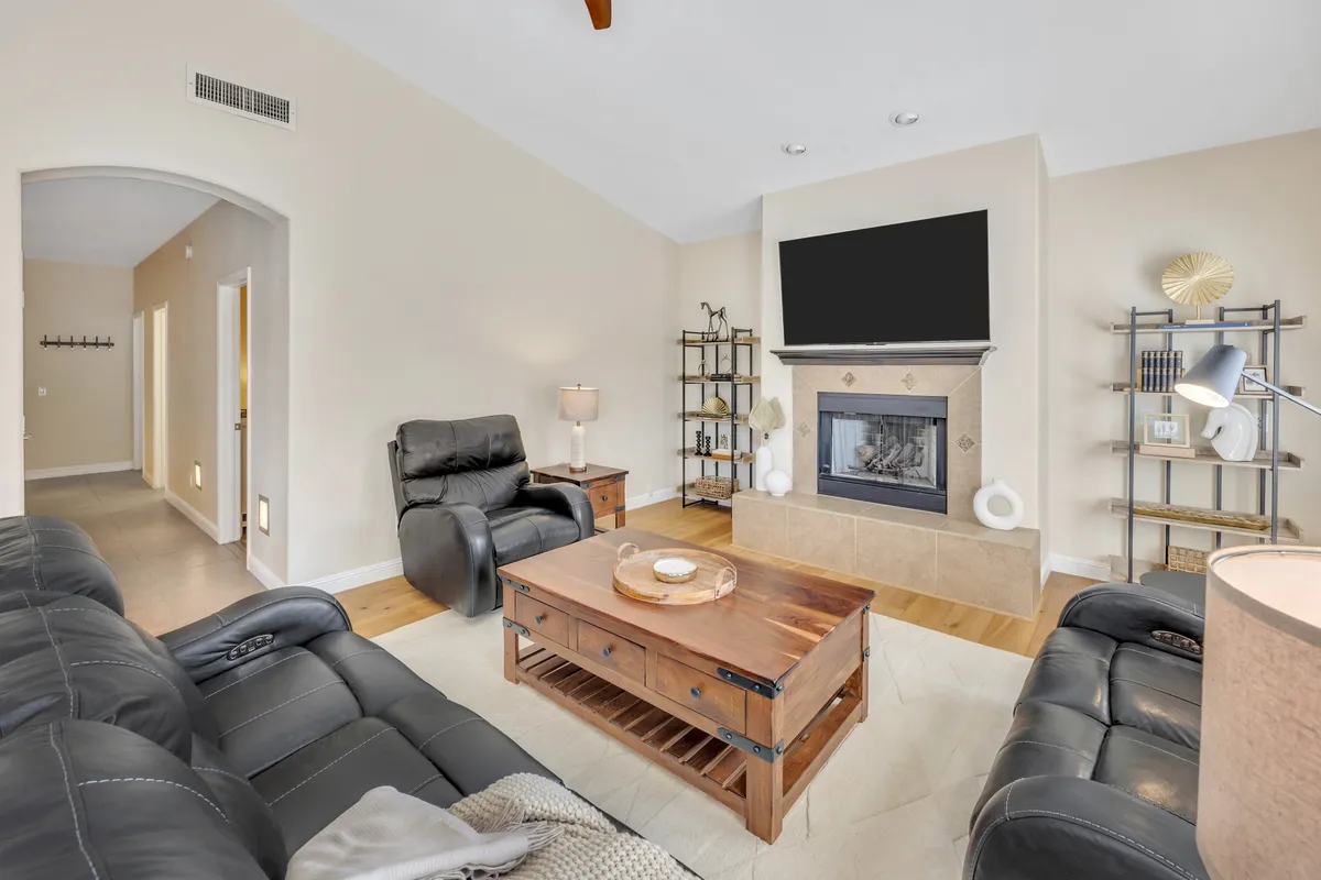 A comfortable sitting area centered around a stylish fireplace, with an inviting seating arrangement and a coffee table perfect for casual gatherings or game nights. Warm lighting and thoughtful decor reinforce the room’s welcoming, relaxing appeal.
