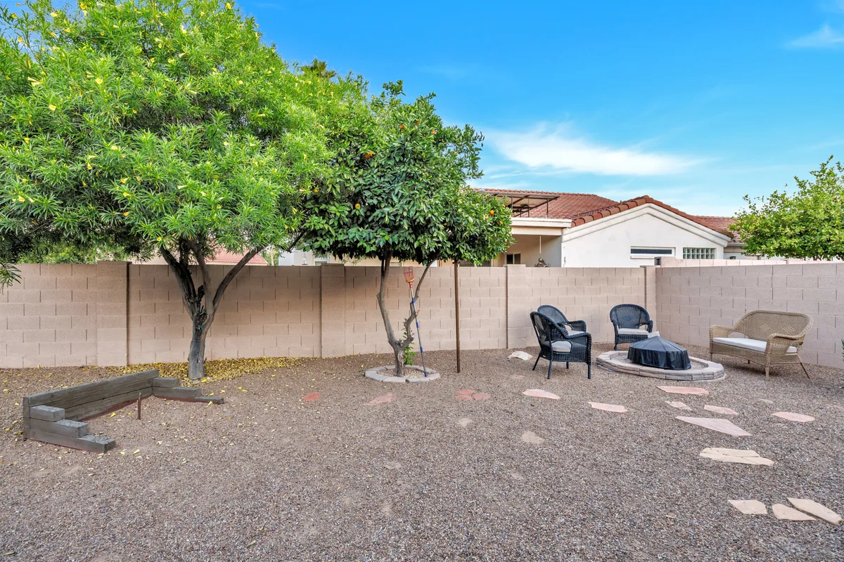 A welcoming fire pit area surrounded by comfortable seating and embraced by mature trees. The setting is intimate and ideal for evening gatherings, sharing stories, or simply enjoying the ambiance of a crackling fire outdoors.